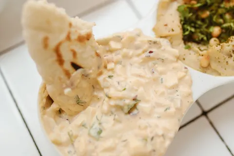 Cremige Fetapaste in einer Schale mit Brot zum Dippen