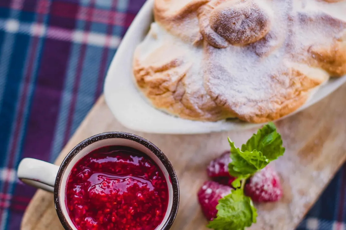 Glas selbstgemachte Himbeermarmelade mit frischen Himbeeren