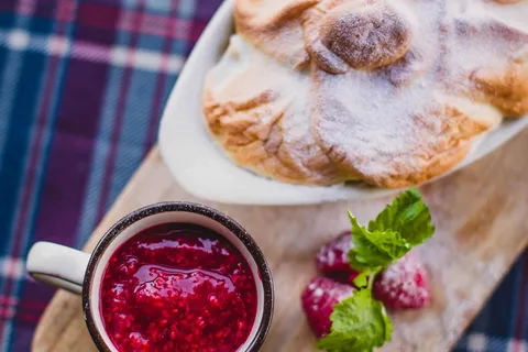 Glas selbstgemachte Himbeermarmelade mit frischen Himbeeren